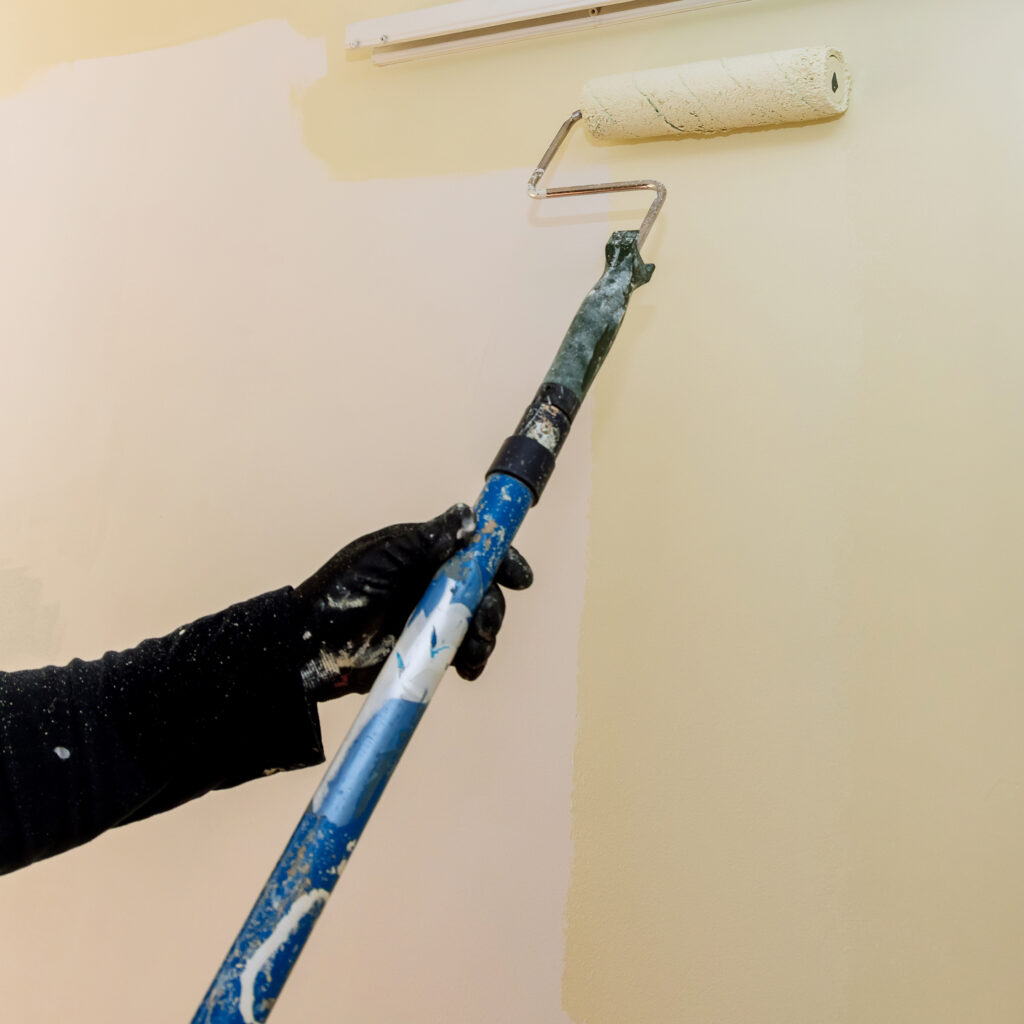 long handle paint roller brush applying color paint wall with home renovation